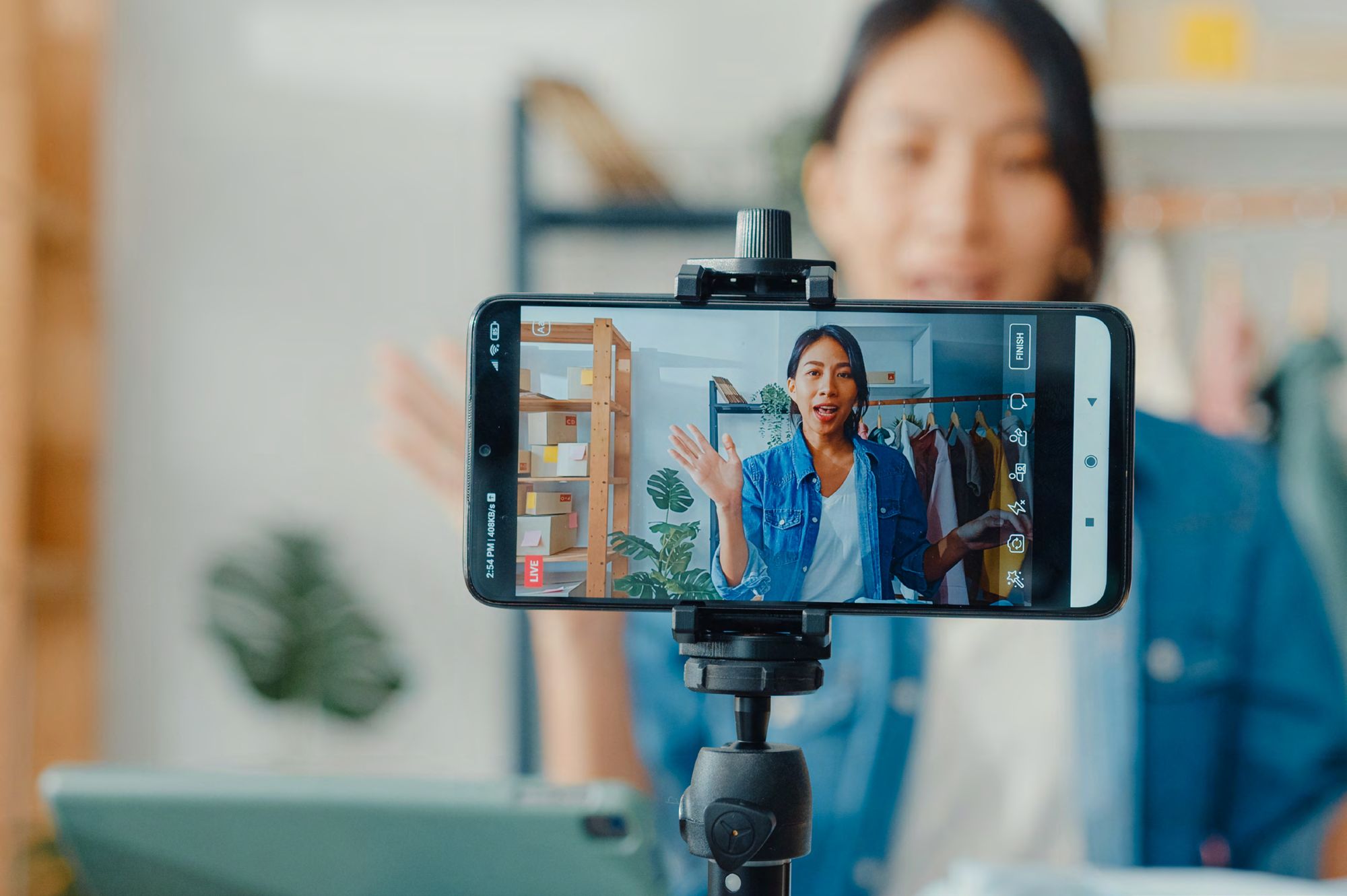 An employee recording a video on a phone mounted on a tripod